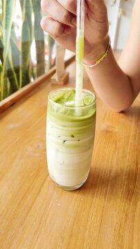 Woman stiring her ice matcha 