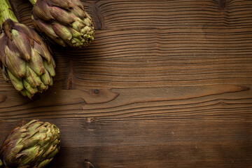 Top view of tree whole heads of purple artichokes. Vegetable ready to cook