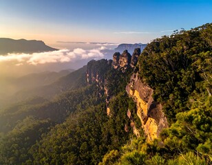 Aerial view of mountain peaks emerging from clouds during sunrise