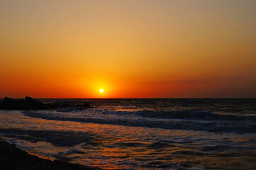 Obraz premium Sunrise on the seashore with waves on a warm summer morning
