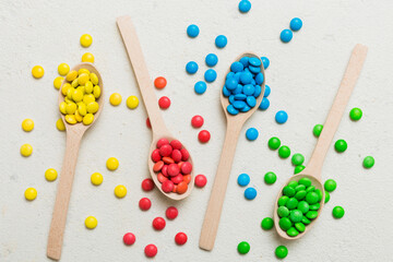 delicious colorful sweet candies on spoon on colored background . Confectionery decor top view with copy space