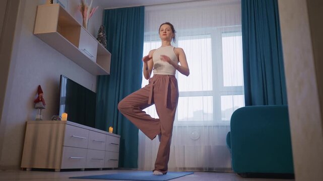 Woman Holds Mountain Pose Calmly At Doorway, Relaxed Woman Maintains Mountain Stance Near Apartment Entrance, Composed Woman Stands In Mountain Pose By Apartment Doorway With Natural Light