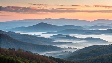 A beautiful panoramic view of layered mountains and valleys filled with mist during sunrise