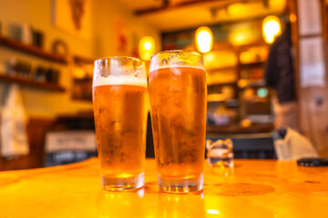 Two cold craft beers resting on table in ucluelet pub