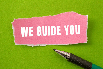 We Guide You message written on ripped torn paper background. Conceptual We Guide You symbol. Copy...