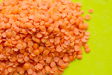 Orange lentils on green surface