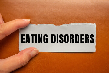 Eating Disorders message written on ripped torn paper background. Conceptual Eating Disorders symbol. Copy space.