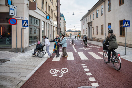Three women and one teenage boy crossing a street in Stockholm, including a person in a wheelchair, illustrating inclusive mobility, accessible infrastructure and sustainable urban transportation