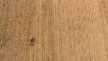 Fototapeta premium Vintage crawler tractor cultivating agricultural land in rural Tuscany, Italy, an aerial top down view of farming preparing soil for sowing crops