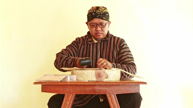 Javanese craftsman carving leather for a Wayang Kulit puppet