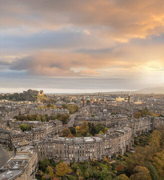 Aerial view of the elegant crescents and stately buildings bathed in the soft glow of sunset, with Edinburgh Castle perched majestically in the distance, Moray Feu, Scotland, United Kingdom.