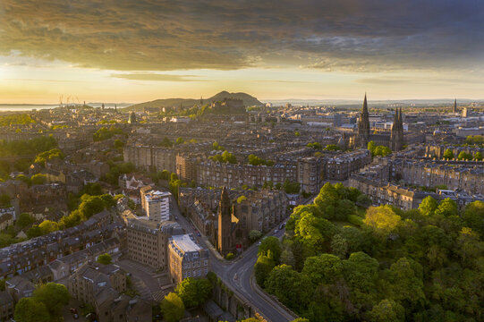 Aerial view of the city bathed in golden sunlight, with a glimpse of Edinburgh Castle and St. Mary's Cathedral, Moray Feu, Scotland, United Kingdom.