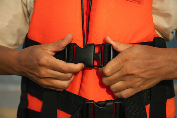 Individual fastens safety gear while preparing for water activity
