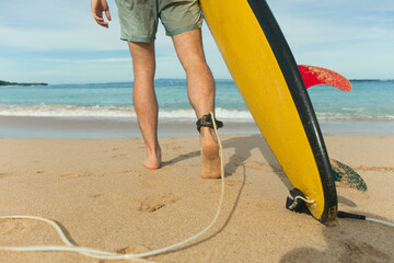 Surfer with a colorful board heads to the water
