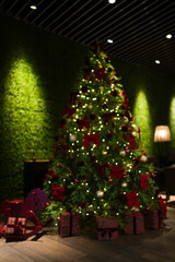 Blurred Christmas tree decorated with lights and ornaments in a cozy restaurant or hotel interior