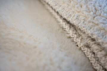 A luxurious macro background of dual-textured fabric. Soft faux fur meets cozy sherpa fleece in a warm cream color, perfect for comfort and design concepts with copy space. ©  Colorshadow
