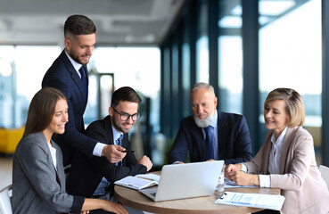 Business team working on laptop to check the results of their work.