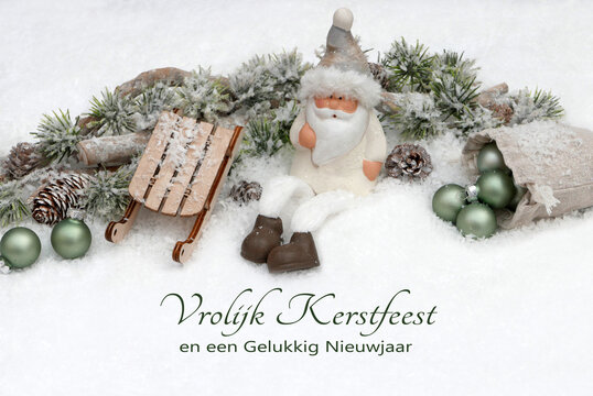 Kerstkaart: Nederlandse kerstgroeten tegen een winterse achtergrond, met kerstversieringen, kerstballen en de Kerstman in de sneeuw. Vrolijk Kerstfeest en een gelukkig nieuwjaar.