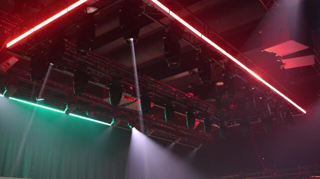 Stage lighting rig with powerful spotlights beams cut through dark hall creating concert mood modern event production technology live show atmosphere energy