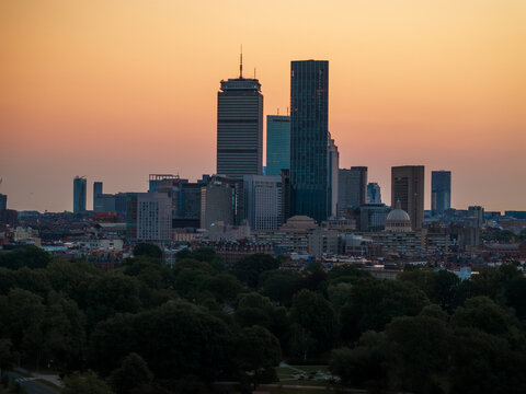 Aerial view of the Boston skyline ablaze with the setting sun, silhouetting the John Hancock Tower and Prudential Center against the fiery sky, Boston, Massachusetts, United States.