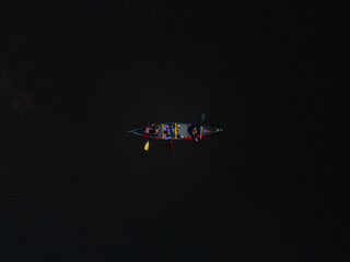 Aerial view of a canoe with people floating on the dark waters creating a striking contrast, Boston, Massachusetts, United States.