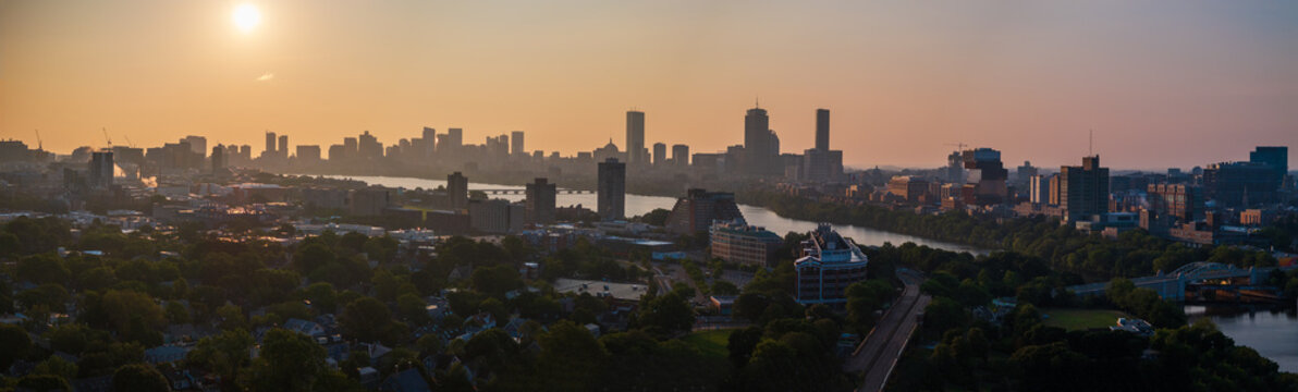Aerial view of the Charles River winding through Boston, with the Hancock and Prudential Towers piercing the skyline against a golden dawn, Boston, Massachusetts, United States.