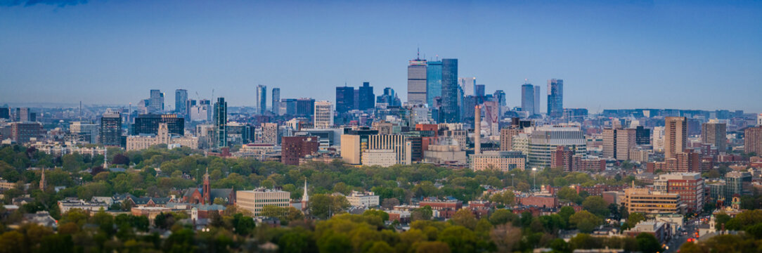 Aerial view of the John Hancock Tower and Prudential Center rise as gleaming giants above a sea of green trees and buildings., Boston, Massachusetts, United States.