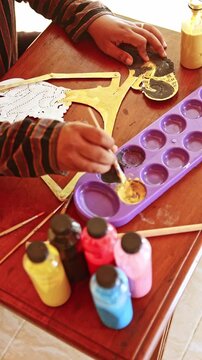 Indonesian artisan painting a traditional wayang kulit puppet