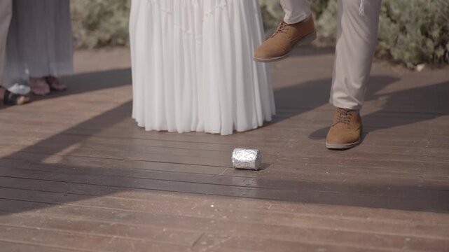 The groom's foot breaking a glass during a traditional jewish wedding ceremony. Symbolic moment representing remembrance and tje beginning of married life.