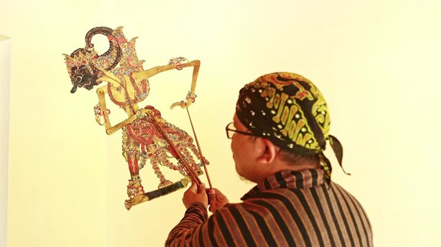 Javanese puppeteer performing traditional wayang kulit show