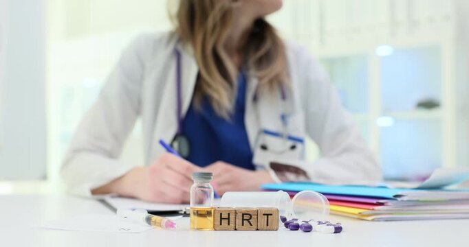 Wooden blocks spell short term HRT near vial and pills on table. Woman doctor plans hormone therapy dosage recording treatment schedule for patient