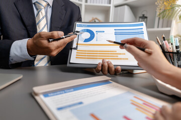 Business professionals reviewing financial charts and performance reports during a meeting, highlighting strategic planning, budget analysis, and teamwork in a modern corporate environment.
