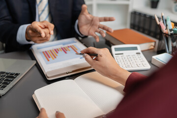 A collaborative startup meeting showing professionals reviewing financial charts and discussing strategic ideas in a modern office setting.
