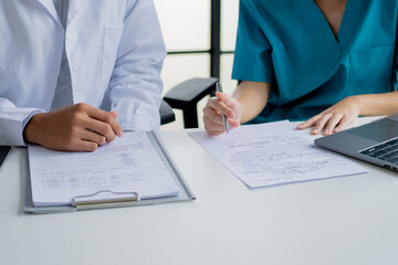 Doctor and nurse consulting on patient medical record in hospital