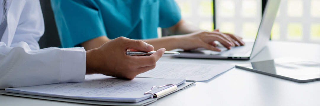 Doctor and nurse consulting on patient medical record in hospital - Powered by Adobe