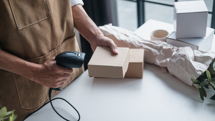 SME owner uses barcode scan on small box for ecommerce logistics