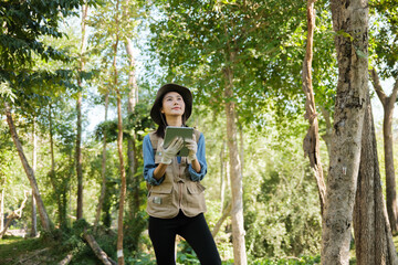 Female botanist studies leaves and grass outdoors in field for eco sustainability
