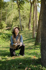 Female botanist observes plants and grass in field for eco agricultural research