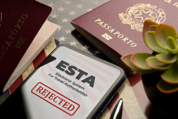 Esta travel authorization rejected displayed on smartphone with passports