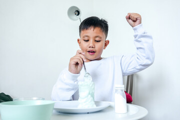 Portrait Of Happy Young Asian Boy Cheering With Raised Fist