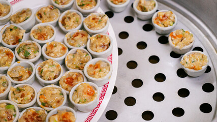 Steamed dumplings on metal steamer tray with copy space
