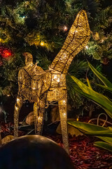 Christmas lights and a decorative reindeer in the night garden.
