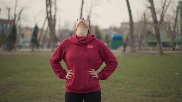 Woman Performs Mindful Neck Stretch, Individual Focuses On Neck Stretching During Peaceful Outdoor Session, Woman Calmly Engages In Mindful Neck Stretching Exercises Amid Nature Environment