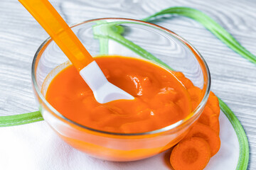 baby food - carrot puree on wooden background