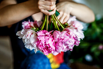 Florist making a bouguet of peonies