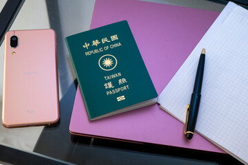 空港の椅子に置かれた携帯電話と台湾のパスポート