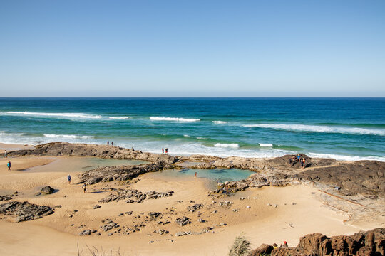 Aerial view of Champagne Pools, where the crashing waves meet the tranquil, sandy shorelines, creating a striking contrast of textures and tones, Fraser Island, Queensland, Australia.