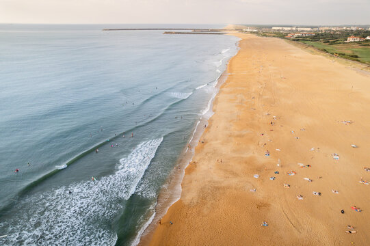 Aerial view of golden sands meeting the turquoise waves at the beach, a vibrant contrast under the soft sky, Anglet, Nouvelle-Aquitaine, France.