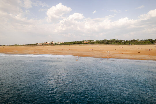 Aerial view of golden sands meet the turquoise sea, a coastal symphony under a vast sky, Anglet, Nouvelle-Aquitaine, France.