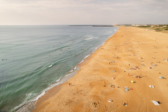 Aerial view of golden sands meeting the turquoise ocean, dotted with sunbathers enjoying the warm summer day, Anglet, Nouvelle-Aquitaine, France.